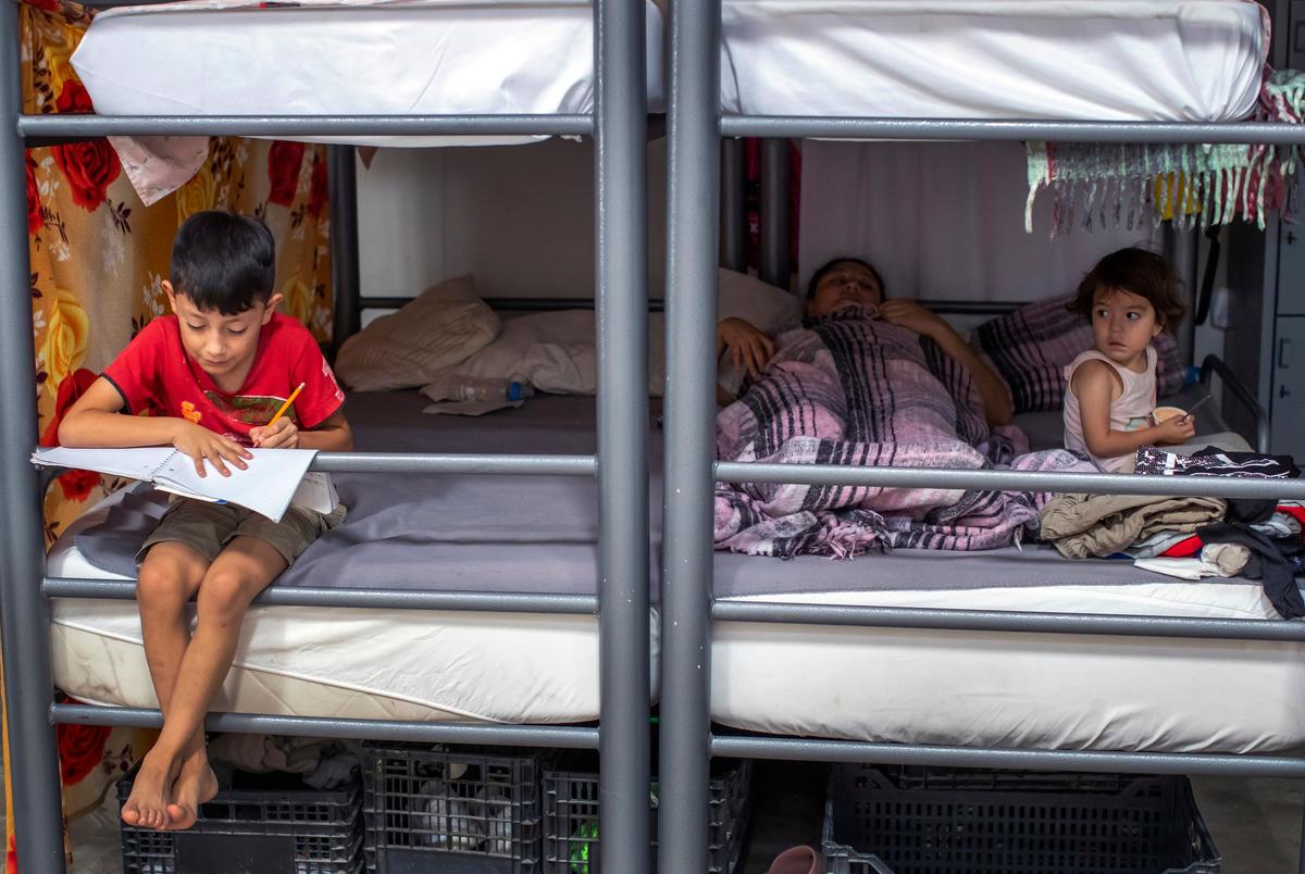 Brayan, 8, and his sister, Linda, 3, sit with their mother at a church-run shelter in Ciudad Juarez, Mexico, while waiting for Customs and Border Protection approval to cross into El Paso, Texas, on Friday, Aug. 9, 2024.