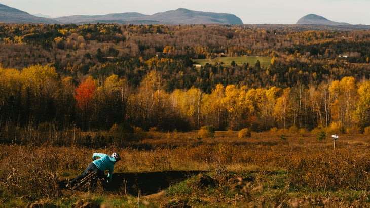 A mountain biker on the Kingdom Trails shreds a berm on the Dashney Loop