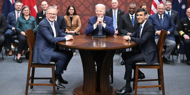 US President Joe Biden, Australian Prime Minister Anthony Albanese, and British Prime Minister Rishi Sunak sitting around a roundtable.