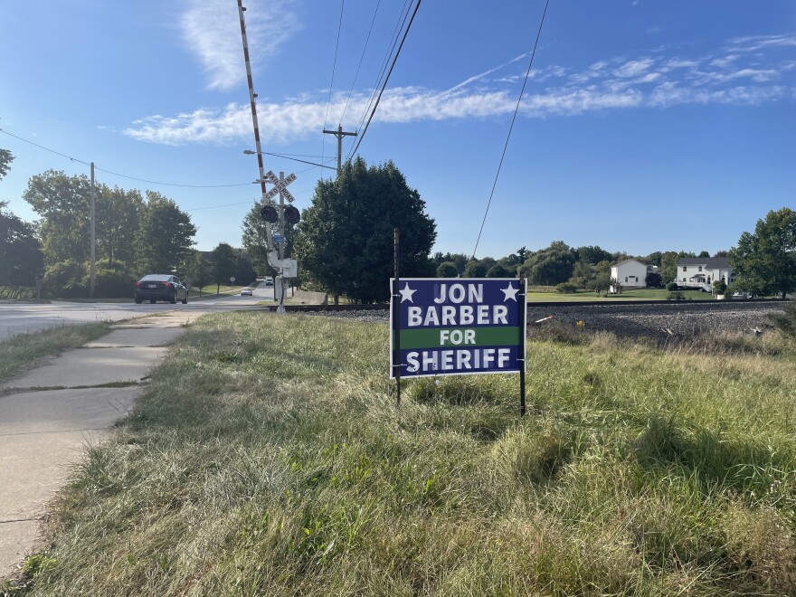 A political sign by a set of railroad tracks read, 