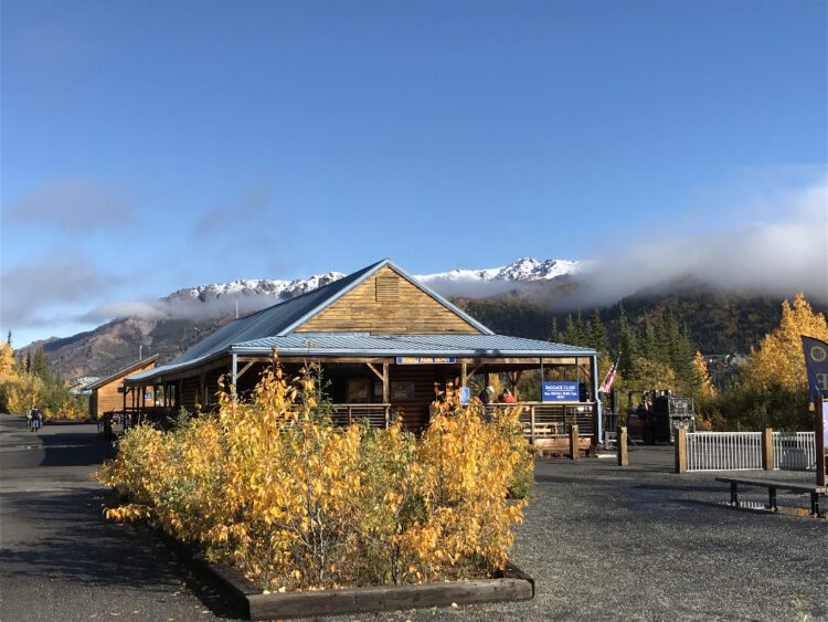 Train depot with snow capped mountain in background. Traveling from winter to fall.