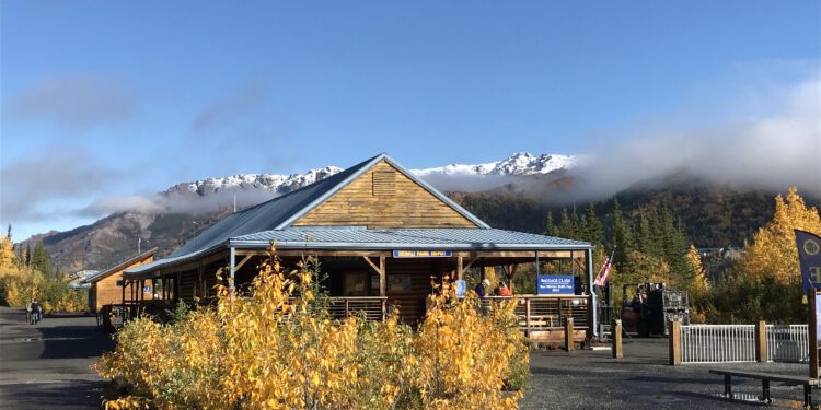 Train depot with snow capped mountain in background. Traveling from winter to fall.