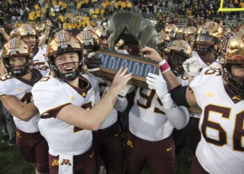 IOWA CITY, IOWA- OCTOBER 21:  Quarterback Athan Kaliakmanis #8  of the Minnesota Golden Gophers celebrates with teammates as they take the Floyd of Rosedale trophy after their match-up against the Iowa Hawkeyes  at Kinnick Stadium on October 21, 2023 in Iowa City, Iowa.  (Photo by Matthew Holst/Getty Images)