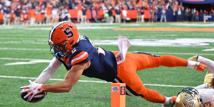 Sep 7, 2024; Syracuse, New York, USA; Syracuse Orange wide receiver Trebor Pena (2) scores a touchdown as Georgia Tech Yellow Jackets defensive back Ahmari Harvey (3) makes a tackle in the first quarter at JMA Wireless Dome. Mandatory Credit: Mark Konezny-Imagn Images