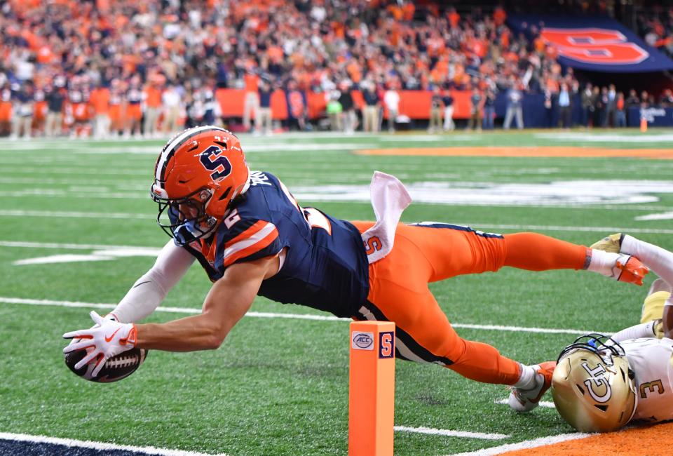 Sep 7, 2024; Syracuse, New York, USA; Syracuse Orange wide receiver Trebor Pena (2) scores a touchdown as Georgia Tech Yellow Jackets defensive back Ahmari Harvey (3) makes a tackle in the first quarter at JMA Wireless Dome. Mandatory Credit: Mark Konezny-Imagn Images