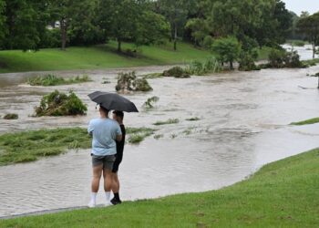 two men look at flooded area