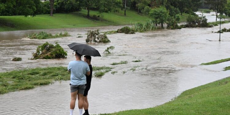 two men look at flooded area