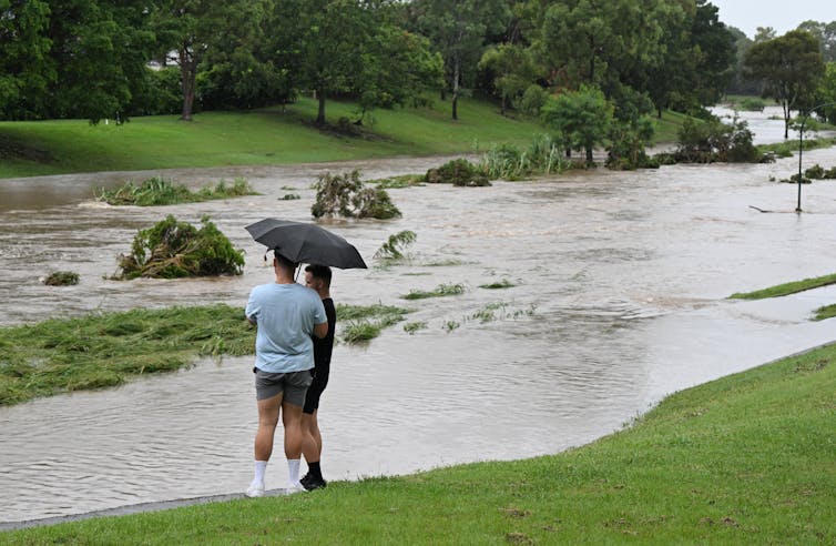 two men look at flooded area