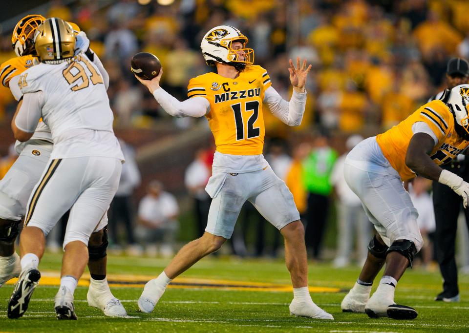 Sep 21, 2024; Columbia, Missouri, USA; Missouri Tigers quarterback Brady Cook (12) throws a touchdown pass against the Vanderbilt Commodores during overtime at Faurot Field at Memorial Stadium. Mandatory Credit: Jay Biggerstaff-Imagn Images