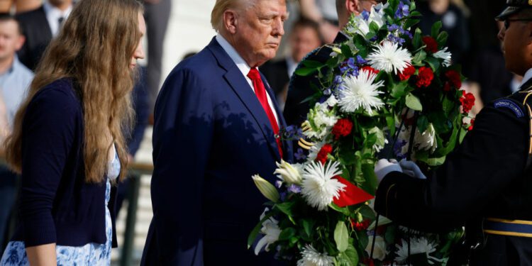 Donald Trump lays a wreath with a fallen soldier’s sister.