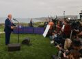 Former U.S. President Donald Trump speaking to reporters off the coast of the Pacific Ocean. Trump is on the left...