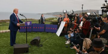 Former U.S. President Donald Trump speaking to reporters off the coast of the Pacific Ocean. Trump is on the left...