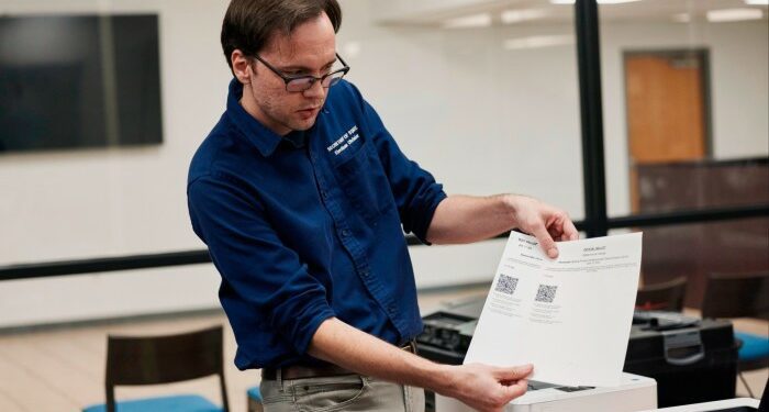 An election official carries out an elections security health check at the Dekalb County election headquarters