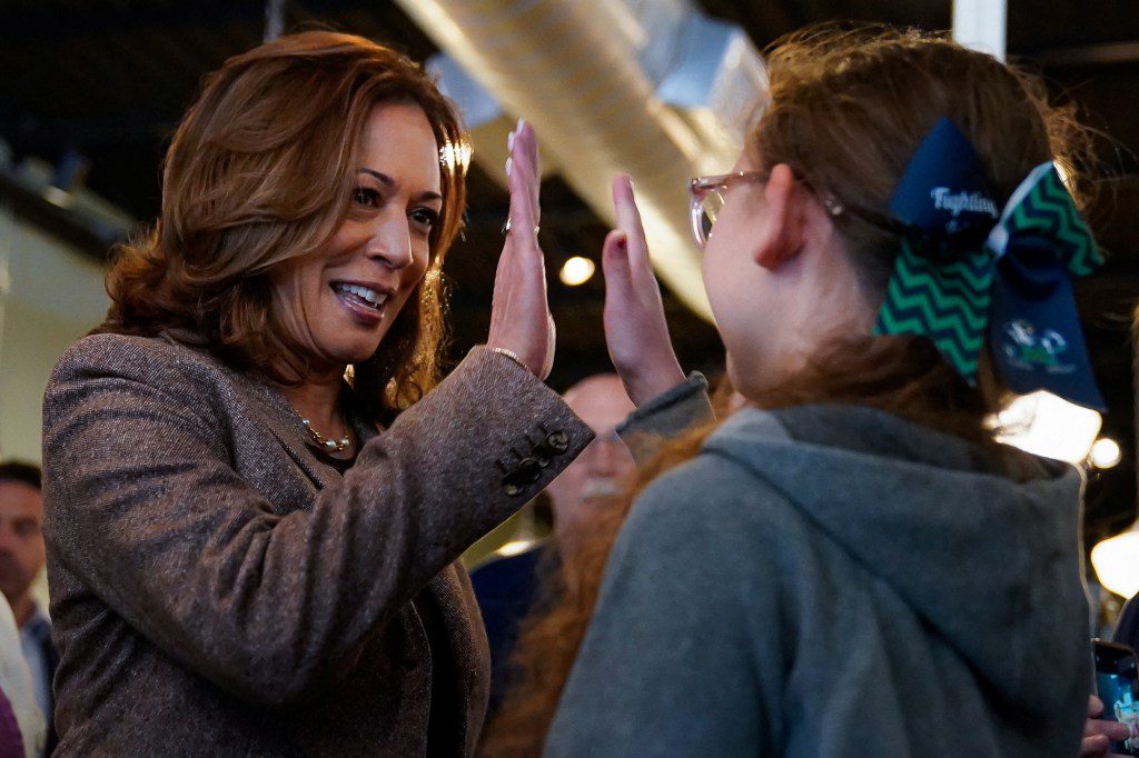 U.S. Vice President Kamala Harris high-fiving a middle school student during her presidential campaign in Pittsburgh, Pennsylvania.