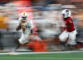 CHARLOTTE, NORTH CAROLINA - SEPTEMBER 07: Dylan Sampson #6 of the Tennessee Volunteers carries the ball for yardage while defended by Aydan White #3 of the NC State Wolfpack during the second half of the Duke's Mayo Classic at Bank of America Stadium on September 07, 2024 in Charlotte, North Carolina. (Photo by Jared C. Tilton/Getty Images)