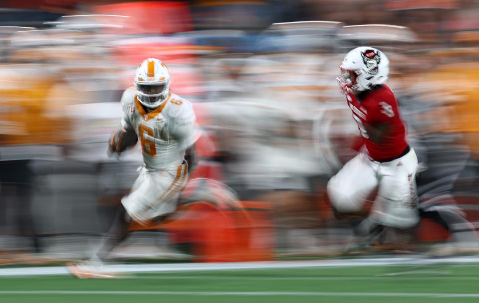 CHARLOTTE, NORTH CAROLINA - SEPTEMBER 07: Dylan Sampson #6 of the Tennessee Volunteers carries the ball for yardage while defended by Aydan White #3 of the NC State Wolfpack during the second half of the Duke's Mayo Classic at Bank of America Stadium on September 07, 2024 in Charlotte, North Carolina. (Photo by Jared C. Tilton/Getty Images)