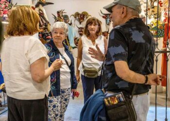 A group of foreigners talking in the middle of an art room.