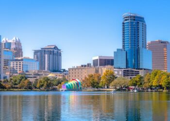 Glass buildings, condos, and offices line the shores of Lake Eola at the heart of Orlando, Fla.