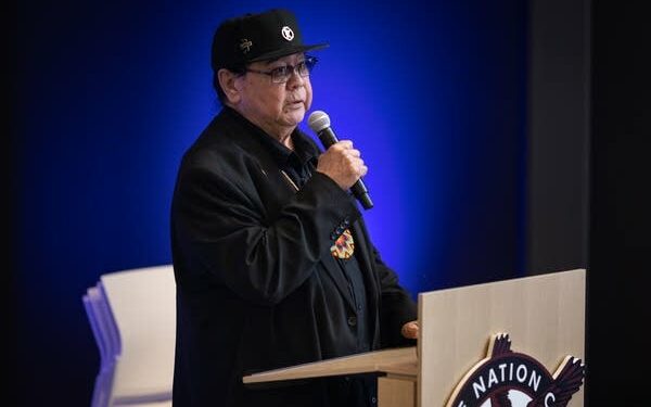 A man speaks into a mic at a podium