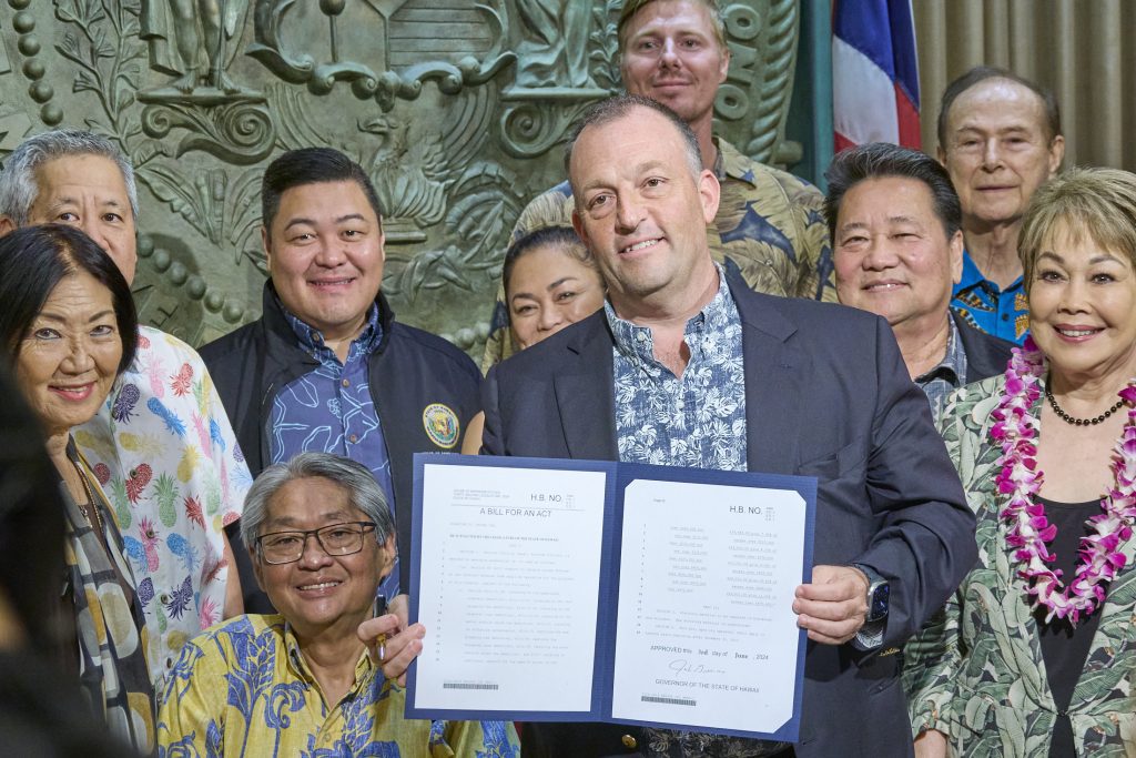 In a packed 5th floor Ceremonial Office in the Hawaii State Capital building, Governor Josh Green M.D., surrounded by State House Representatives and Senators along with members of the medical profession, signed two bills into law on Monday that aim to reduce State Income Tax and GET taxes on Medicare, Medicaid and Tricare services beginning in 2026 signaling the biggest tax cuts in Hawaii history. (David Croxford/Civil Beat/2024)