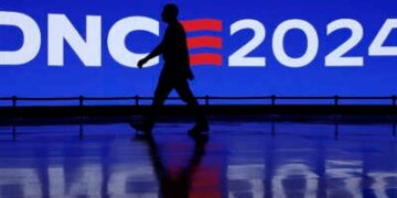 A man walks by a Democratic National Convention 2024 sign at the United Center on August 18, 2024, in Chicago, Illinois.