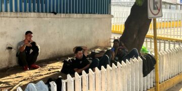 Migrants rest by bus station