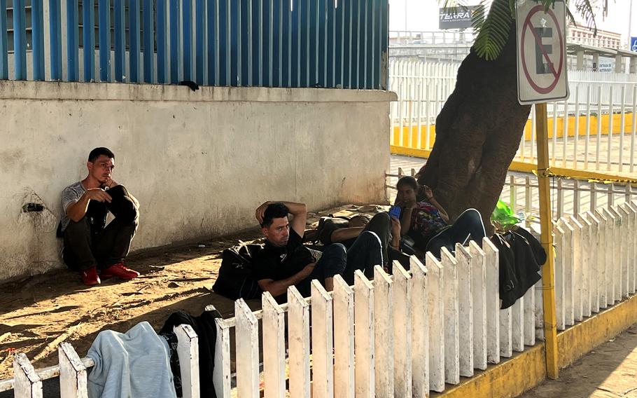 Migrants rest by bus station