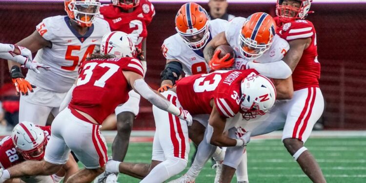 Oct 29, 2022; Lincoln, Nebraska, USA; Illinois Fighting Illini running back Chase Brown (2) runs the ball against Nebraska Cornhuskers defenders during the fourth quarter at Memorial Stadium. Mandatory Credit: Dylan Widger-USA TODAY Sports