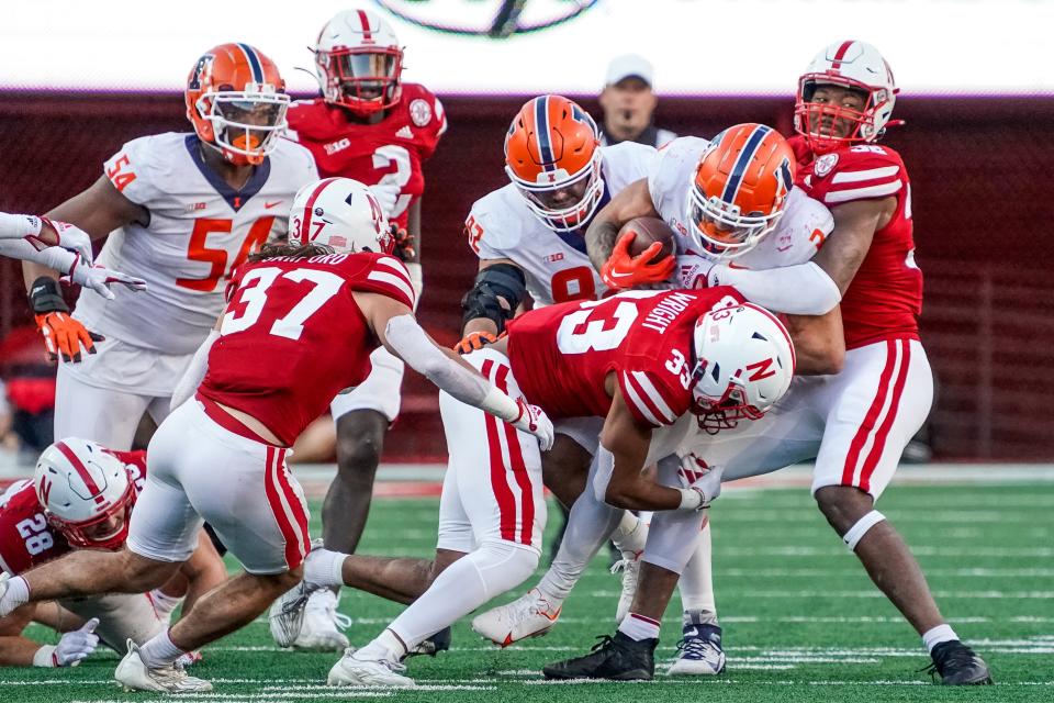 Oct 29, 2022; Lincoln, Nebraska, USA; Illinois Fighting Illini running back Chase Brown (2) runs the ball against Nebraska Cornhuskers defenders during the fourth quarter at Memorial Stadium. Mandatory Credit: Dylan Widger-USA TODAY Sports