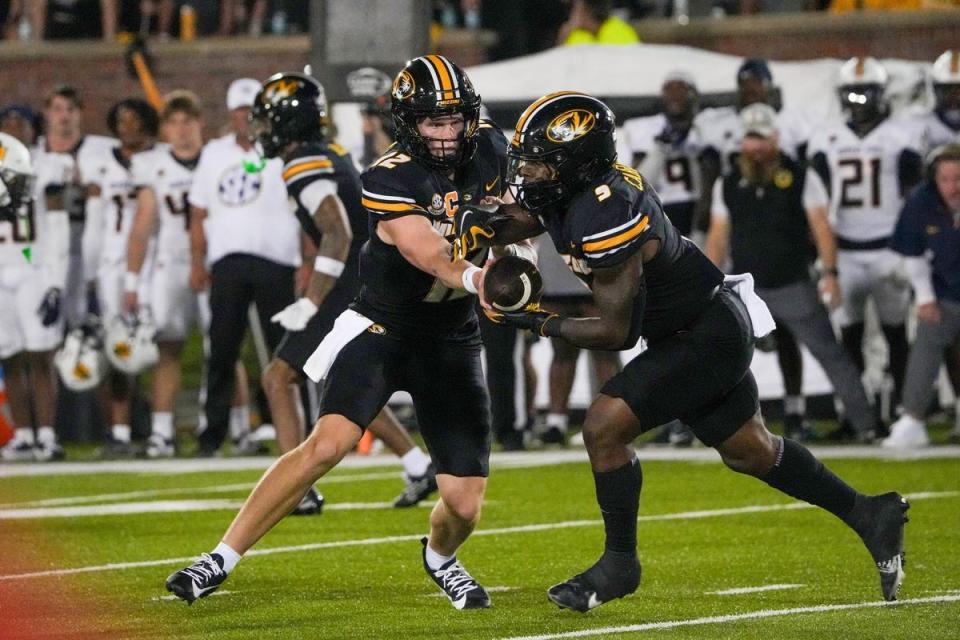 Aug 29, 2024; Columbia, Missouri, USA; Missouri Tigers quarterback Brady Cook (12) hands off to running back Marcus Carroll (9) against the Murray State Racers during the first half at Faurot Field at Memorial Stadium. Mandatory Credit: Denny Medley-Imagn Images