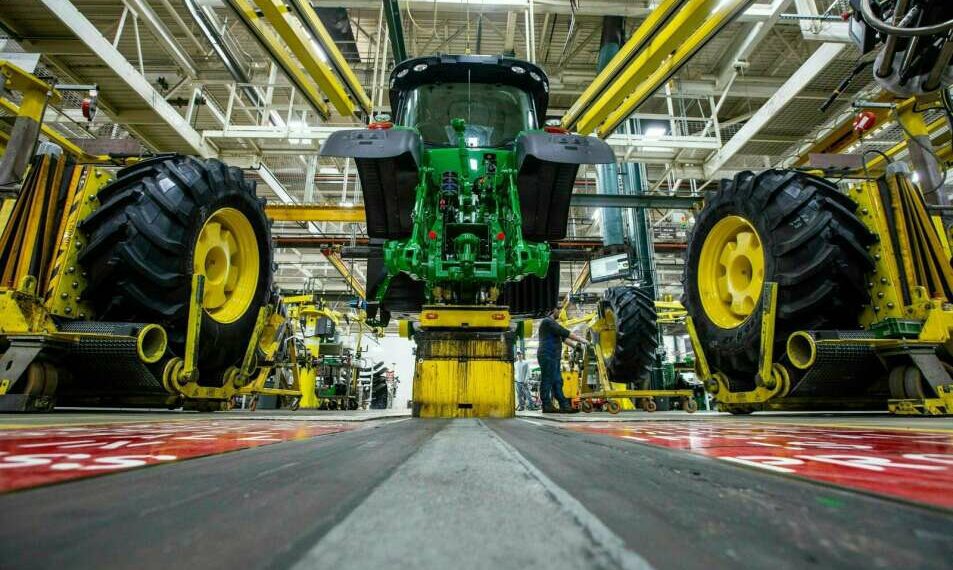 In this April 9, 2019 photo, wheels are attach as workers assemble a tractor at John Deere's Waterloo assembly plant. (Zach Boyden-Holmes/Telegraph Herald via AP, File)