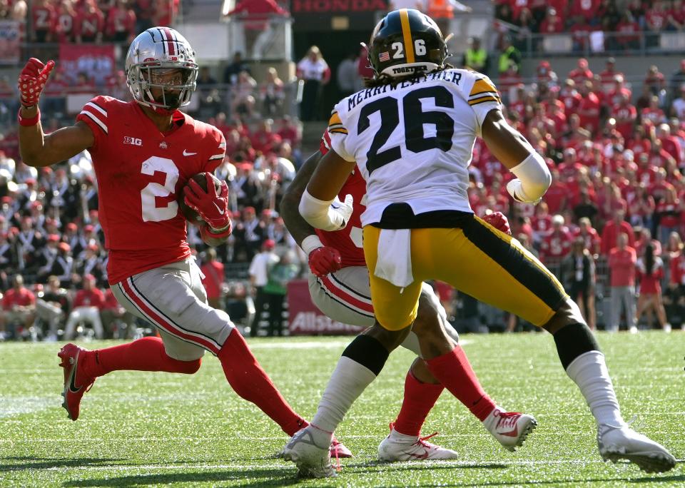 Oct 22, 2022; Columbus, Ohio, USA; Ohio State Buckeyes wide receiver Emeka Egbuka (2) avoids Iowa Hawkeyes defensive back Kaevon Merriweather (26) in their NCAA Division I football game between the Ohio State Buckeyes and the Iowa Hawkeyes at Ohio Stadium. Mandatory Credit: Brooke LaValley/Columbus Dispatch