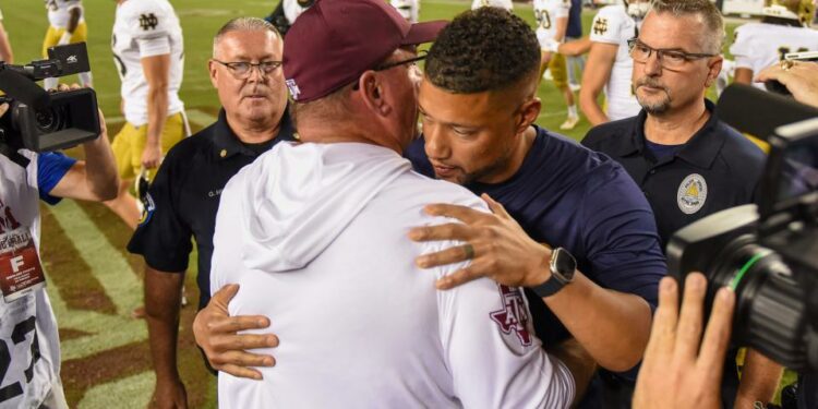 COLLEGE STATION, TEXAS - AUGUST 31: Head coach Marcus Freeman of the Notre Dame Fighting Irish and head coach Mike Elko of the Texas A&M Aggies embrace after the game at Kyle Field on August 31, 2024 in College Station, Texas. (Photo by Jack Gorman/Getty Images)