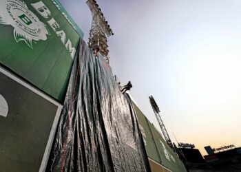 A tarp covered the Green Monster as firefighters rappelled during the joint training event.