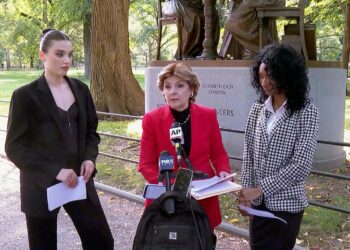 Flanked by Veronika Didusenko, left, and Danielle Hazel, right, attorney Gloria Allred, center, speaks during a news conference on September 16, 2024, in New York.