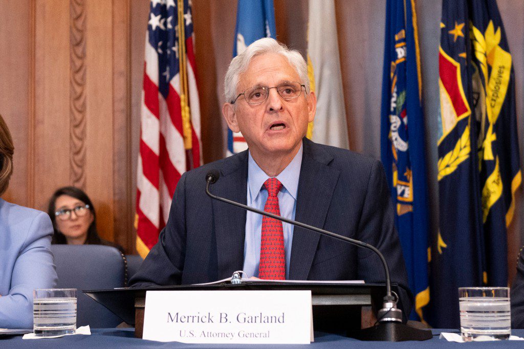 US Attorney General Merrick Garland speaking at a podium during a meeting of the Justice Department's Election Threats Task Force