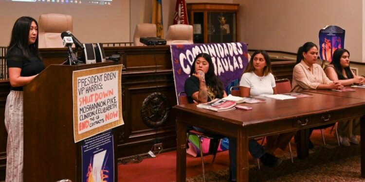 A woman stands at a podium discussing a report about conditions at an immigrant detention center