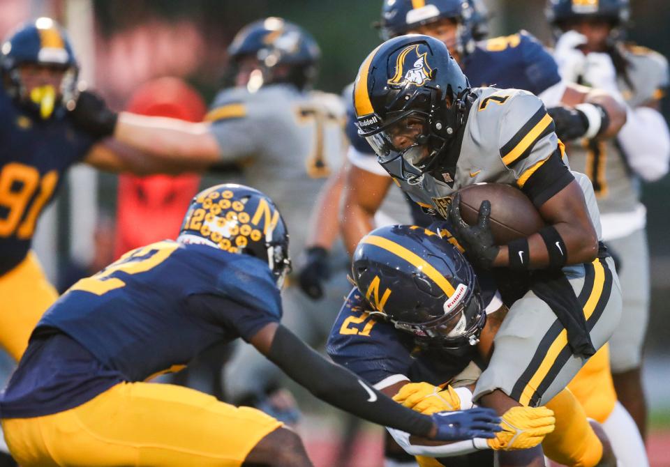 American Heritage Patriots running back Byron Louis (7) is tackled by Naples Golden Eagles linebacker Khari Bendolph (21) during the first quarter of a game at Staver Field in Naples on Friday, Sept. 13, 2024.