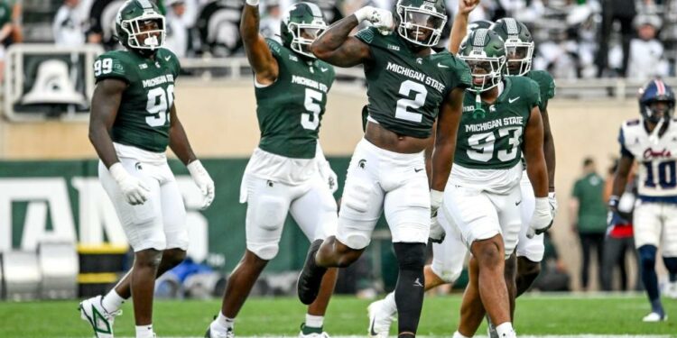 Michigan State's Khris Bogle, center, celebrates his stop against Florida Atlantic during the first quarter on Friday, Aug. 30, 2024, at Spartan Stadium in East Lansing.