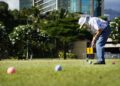 Gateball player Steven Kaneshiro strikes a ball toward the first gate during practice Wednesday, Sept. 4, 2024, at Ala Moana Beach Park in Honolulu. Kaneshiro discovered the sport after re-connecting with Art Kimura. Kimura was one of Kaneshiro’s high-school teachers. (Kevin Fujii/Civil Beat/2024)