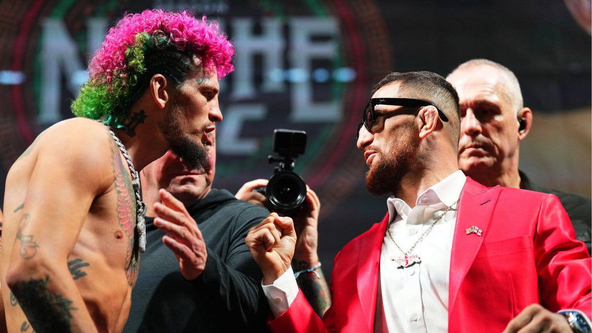 UFC fighters Sean O'Malley and Merab Dvalishvili facing each other, arguing.