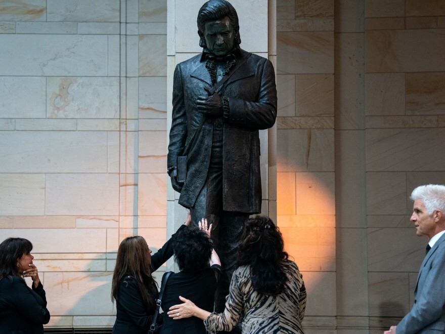  Joanne Cash, sister of the singer Johnny Cash, reached out to touch the statue of her late brother at the unveiling in the U.S. Capitol on Tuesday. Rosanne Cash, daughter of Johnny Cash, told the audience at the event that her aunt had lost her sight and asked that she have the opportunity to feel the statue to appreciate it.