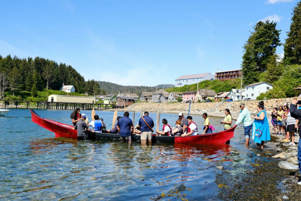 Angoon students prepare to paddle the unity canoe they built with master carver Wayne Price on June 19, 2023. It is the first canoe of its kind since the U.S. Navy bombardment of Angoon in 1882 that destroyed all the villages canoes. The Navy plans to issue apologies to Kake and Angoon residents in the fall of 2024. (Claire Stremple/Alaska Beacon)