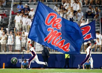 Aug 31, 2024; Oxford, Mississippi, USA; Mississippi Rebels Cheerleaders run the Ole Miss flag across the field after a touchdown during the second half against the Furman Paladins at Vaught-Hemingway Stadium. Mandatory Credit: Petre Thomas-USA TODAY Sports