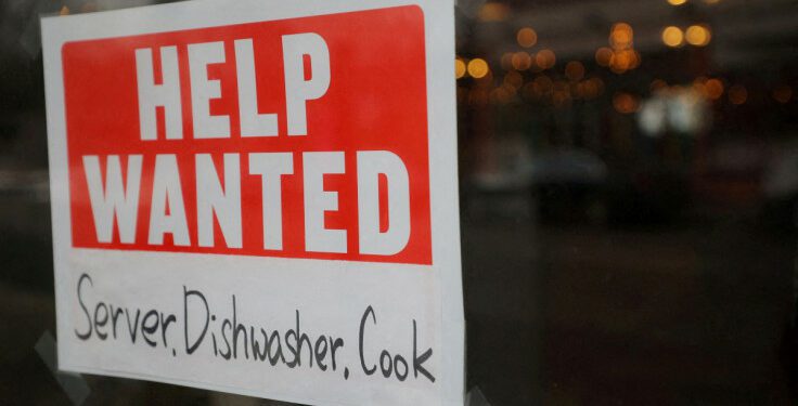 A “Help Wanted” sign hangs in restaurant window in Medford