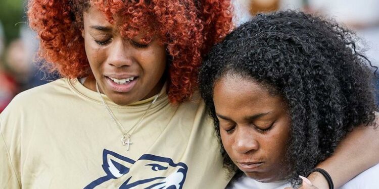 A close up portrait of two women crying at a vigil for the victims at Apalachee High School in Winder, Georgia on 4 September