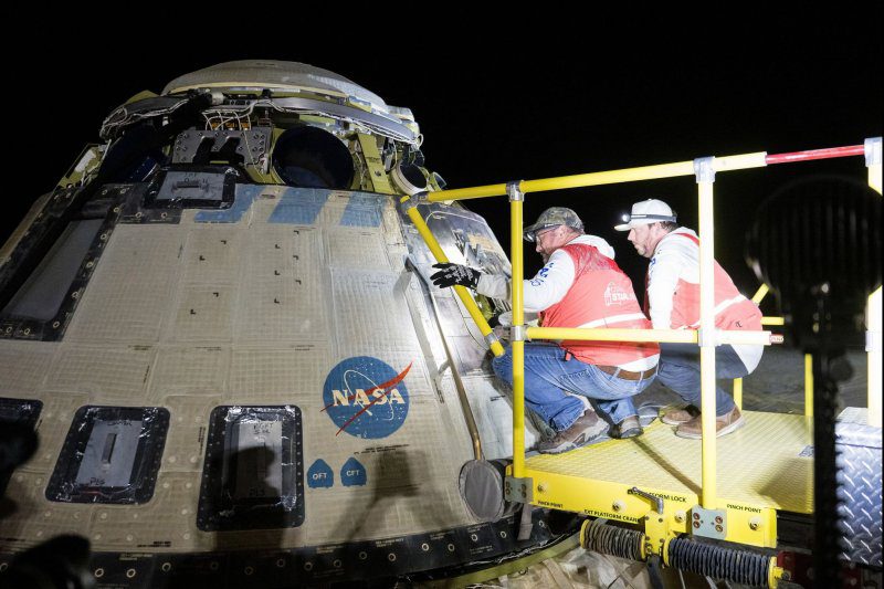 Boeing and NASA teams work around NASA's Boeing Starliner spacecraft after it landed uncrewed on Friday at White Sands, N.M. NASA Photo by Aubrey Gemignani/UPI