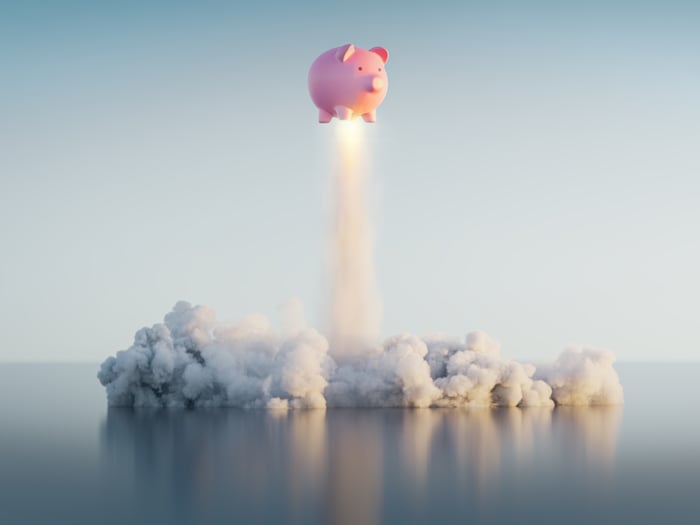 A piggy bank blasts off like a rocket.