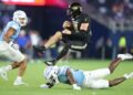 Lindenwood Lions quarterback Nate Glantz (18) jumps over Kansas Jayhawks safety Taylor Davis (27) in the fourth quarter of the game Thursday, August 29, 2024 at Children's Mercy Park.