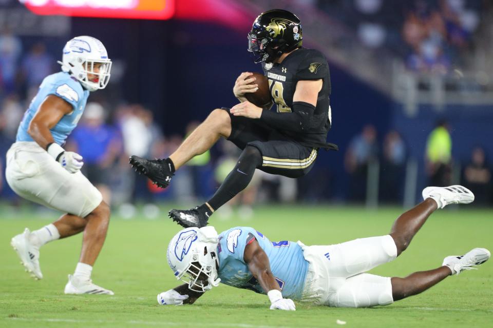 Lindenwood Lions quarterback Nate Glantz (18) jumps over Kansas Jayhawks safety Taylor Davis (27) in the fourth quarter of the game Thursday, August 29, 2024 at Children's Mercy Park.